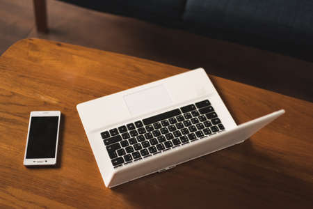 laptop and smartphone on the table with nobody, concept of working at homeの写真素材