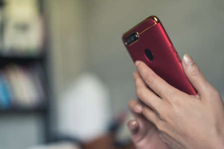 woman using smartphone on bed at homeの写真素材