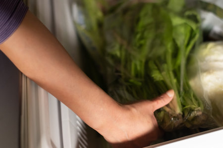 woman take vegetables from refrigerator at home