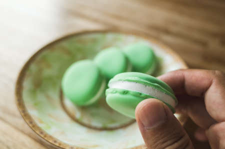 pick a macaron by hand, closeup imageの写真素材