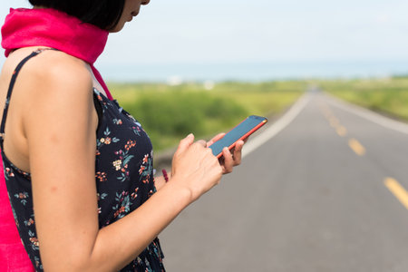 traveling woman walk and use a cellphone on the road