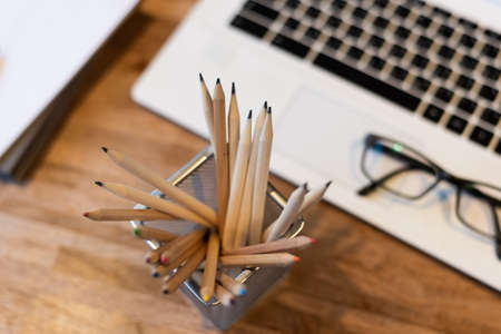 pencils and laptop on the table with nobodyの写真素材