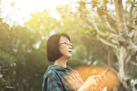 portrait of Asian mature woman using cellphone at the streetの写真素材