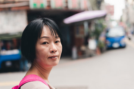 Asian traveling mature woman walk at the traditional marketplace in Taiwan