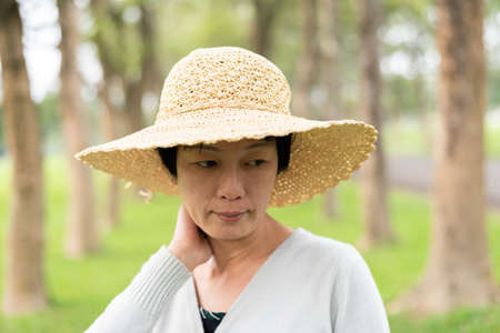 shy mature Asian beauty with a hat in the outdoorの写真素材