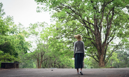 Asian woman take a walk on the way under the trees