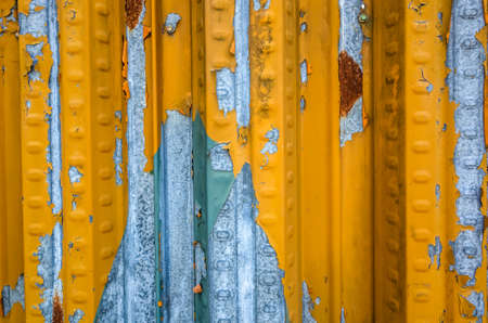 weathered metal wall in yellow and blue colorの写真素材