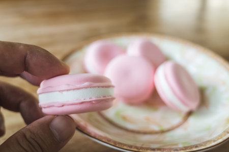 pick a macaron by hand, closeup image