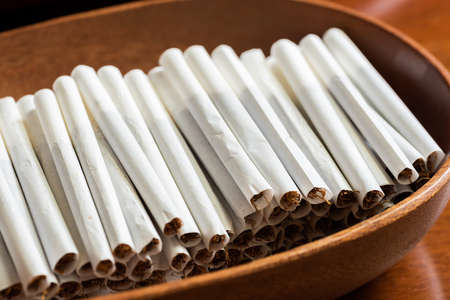 closeup images with homemade cigarettes on a wooden tableの写真素材