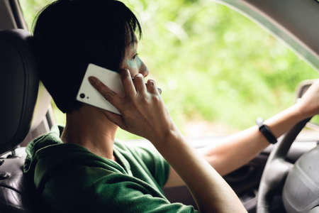 woman talking on cellphone when driving, concept of dangerous driverの写真素材