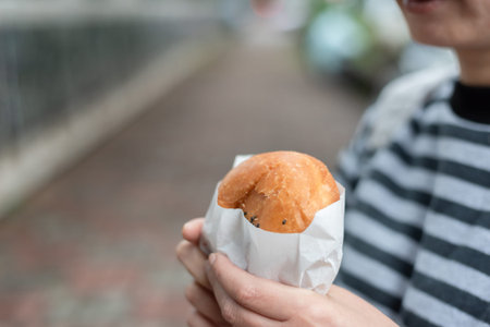 woman eat traditional Taiwanese snack at a street