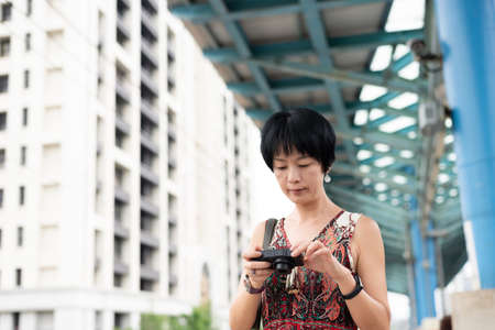 Asian woman using digital camera at a train platform in the outsideの写真素材