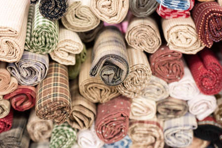 background of colorful fabric stacks in a mallの写真素材