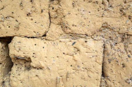 old yellow mud brick wall background with good textureの写真素材