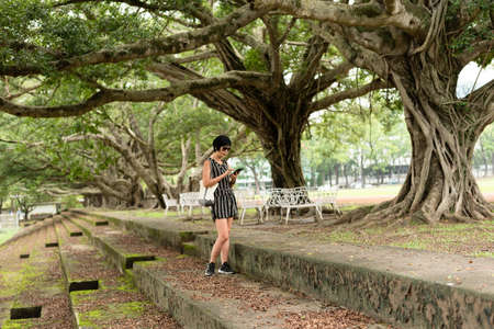 mature Asian woman stand on a stairs and use cellphoneの写真素材