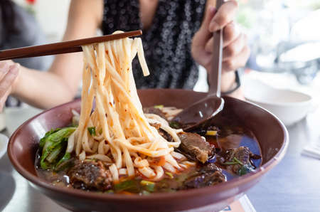 a bowl of hot braised beef noodle soupの写真素材