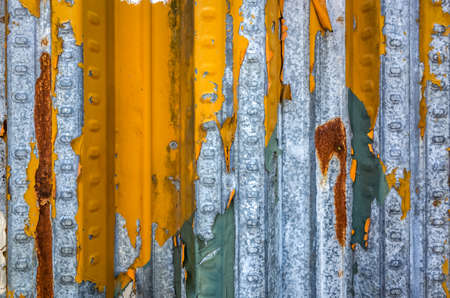 weathered metal wall in yellow and blue colorの写真素材