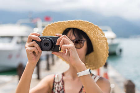 traveling Asian woman with hat take a pictures at Sun Moon Lake, Taiwanの写真素材