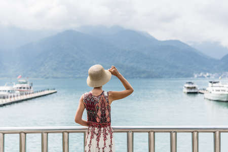 traveling Asian woman with hat standing at Sun Moon Lake, Taiwanの写真素材