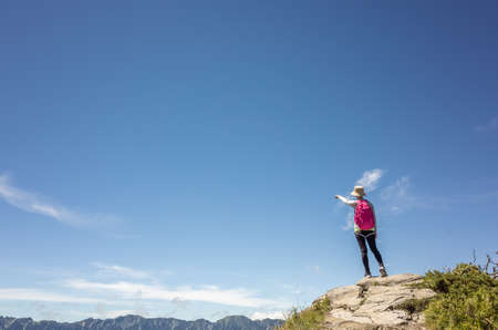 Asian mountain climbing woman pointing at far away in Hehuan mountain, Taiwanの写真素材