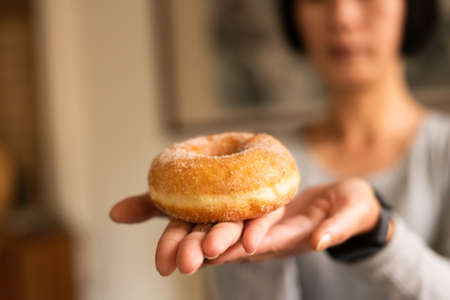 take a donut by woman's hand in houseの写真素材