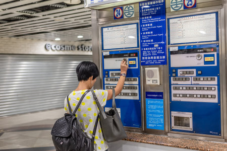 Taipei, Taiwan - May 10th, 2019:woman buying at ticket machine in the train station, Taipei, Taiwan,...