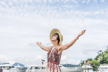 traveling Asian woman with hat open arms at Sun Moon Lake, Taiwanの写真素材