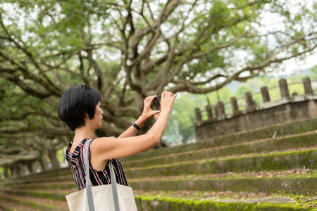 mature Asian woman stand on a stairs and take a pictureの写真素材