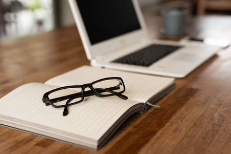 glasses on the notebook on the table, concept of plan, business, workingの写真素材