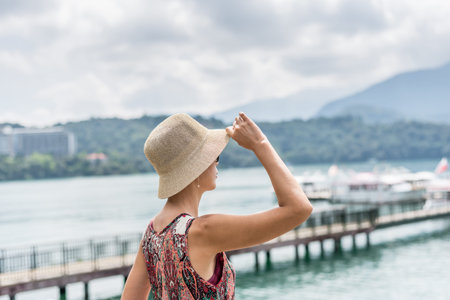 traveling Asian woman with hat standing at Sun Moon Lake, Taiwanの写真素材