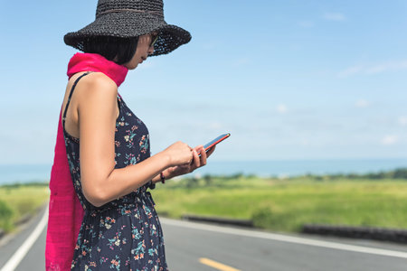 traveling woman walk and use a cellphone on the road