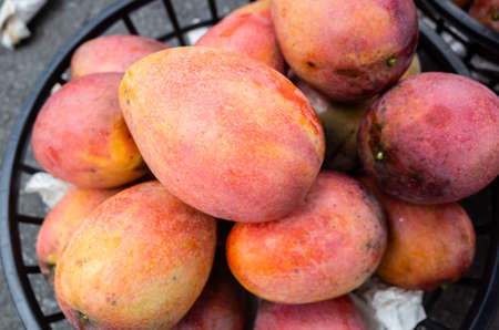 stacks of mango fruits in a basket at traditional marketplace, Taiwanの写真素材