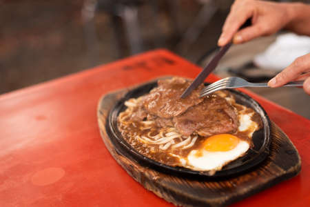woman eat Taiwanese night market steak at the streetの写真素材