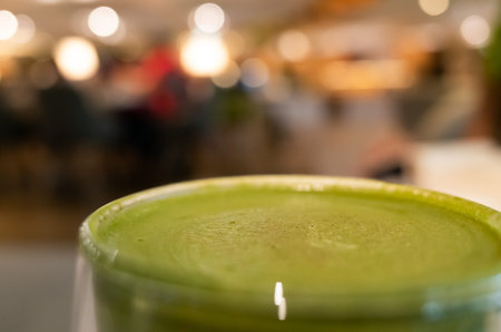 cup of matcha milk tea on table in a coffee shopの写真素材