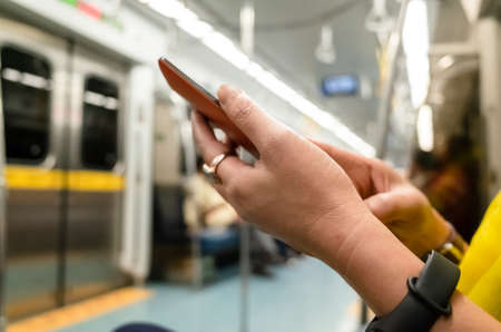 using smartphone at the MRT carriage with copyspaceの写真素材