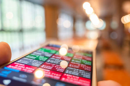 using a mobile device to check market data with bokeh copyspaceの写真素材