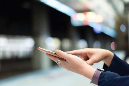 using cellphone in the rail station with copyspaceの写真素材
