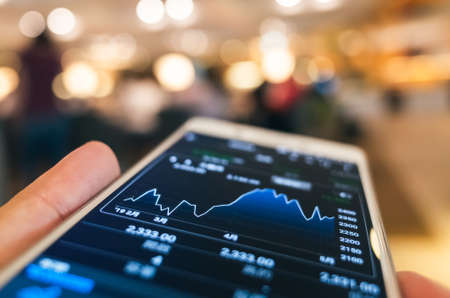 using a mobile device to check market data with bokeh copyspaceの写真素材