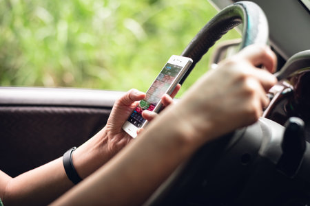 woman using smartphone in a car, concept of dangerous driving