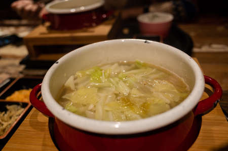 closeup image of woman eating hot pot with vegetables and porkの写真素材