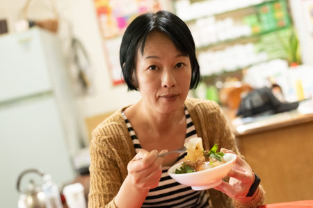 Asian woman eat Taiwanese Meatballs at a store