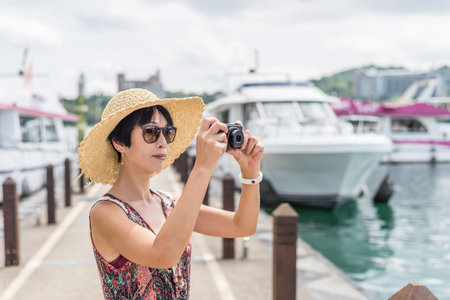 traveling Asian woman with hat take a pictures at Sun Moon Lake, Taiwan