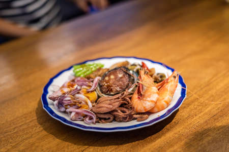 people eat plate of seafood on table in a restaurantの写真素材