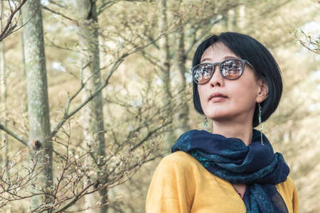 closeup portrait of modern Asian mature woman at the forestの写真素材
