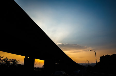 sunset landscape with dramatic clouds over the silhouette tower in a city