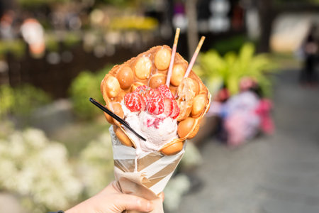 woman eat a waffle ice cream with strawberries at a street