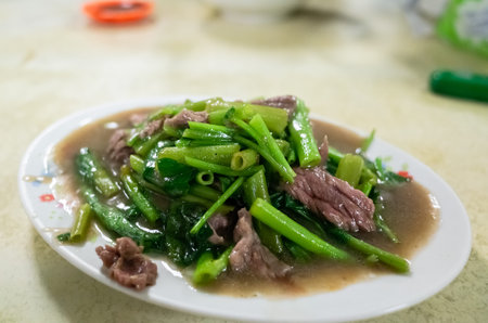 taiwanese snack of beef with water spinach on a plate in a restaurant