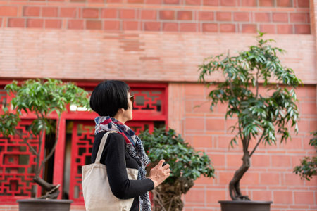 modern Asian woman hold a camera traveling at an old Chinese buildings