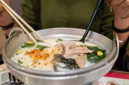 woman eat a bowl of tonkotsu ramen in the restaurantの写真素材