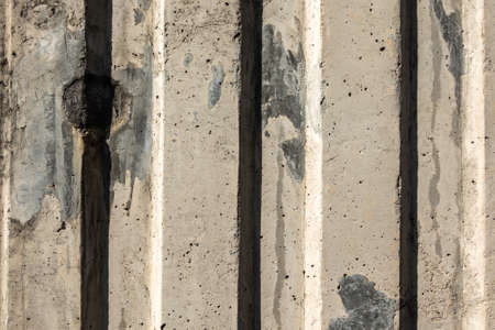 gray cement wall with vertical lines and shadowの写真素材